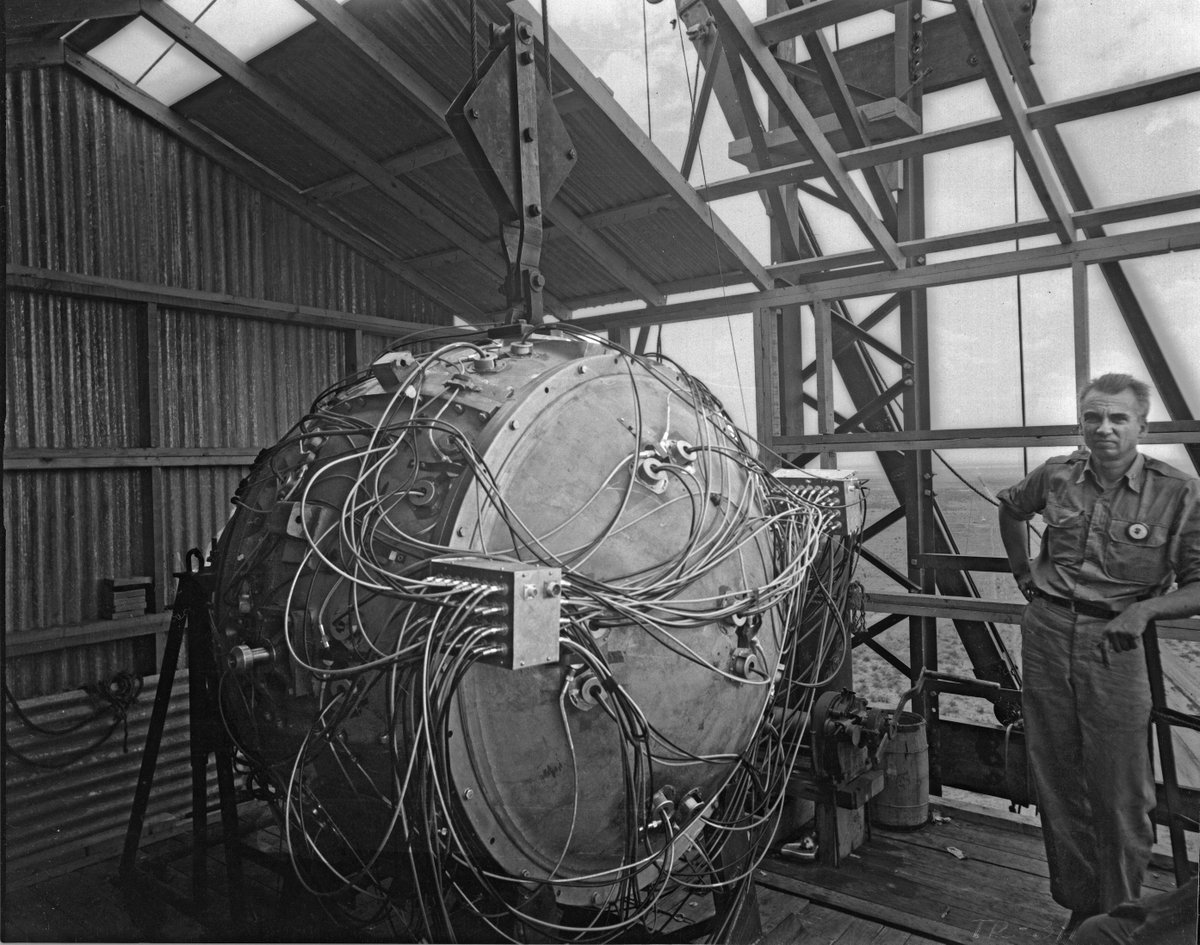 HistoryofWarMag's tweet image. Today marks 80 years since the first atomic bomb was successfully detonated during the Trinity Test. Pictured, Norris Bradbury, group leader for bomb assembly, stands next to the partially assembled Gadget atop the test tower (Federal US Govt via Wikimedia Commons).