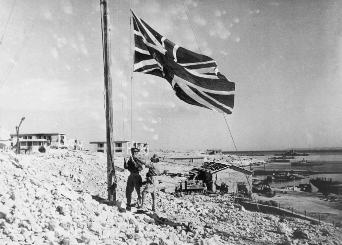 Empireaesth's tweet image. An officer raises the Union Flag among the ruins of Tobruk (1942)