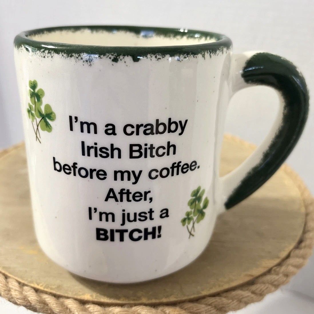 White mug with green accents and shamrocks, and san serif text reading "I'm a crabby Irish Bitch before my coffee. After, I'm just a BITCH!"