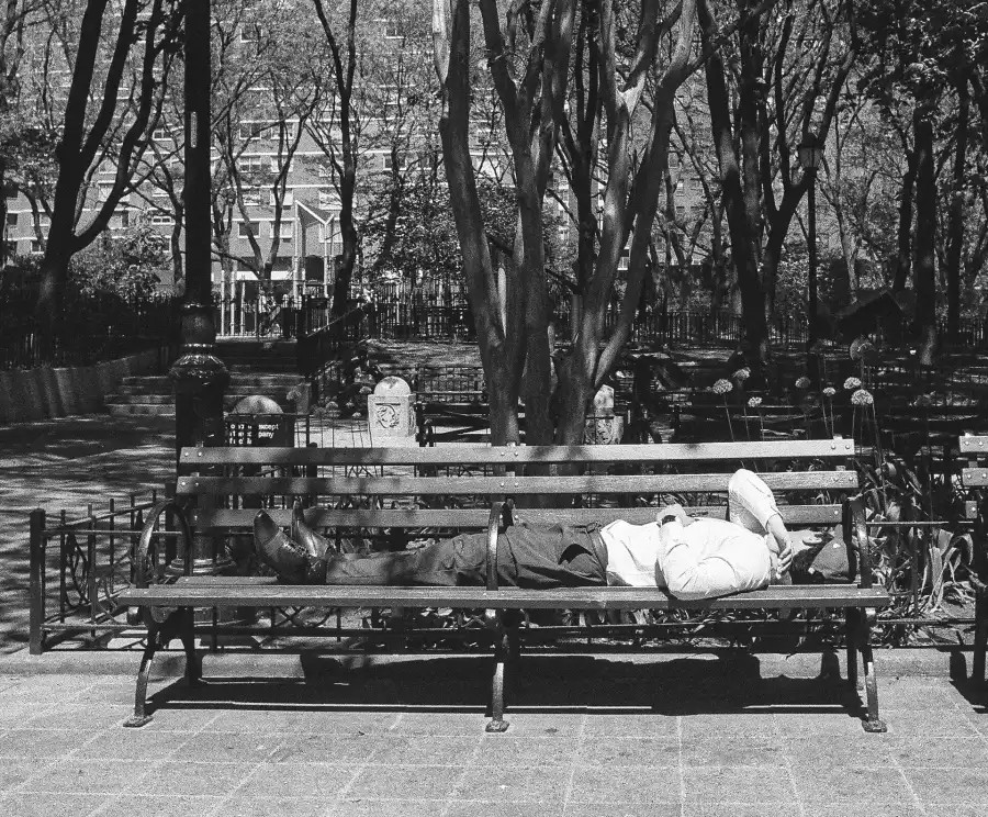 homeless_new's tweet image. @Dean_Moses shows his black and white photos of New Yorkers in summer heat. One shows a man on a wooden bench with round cast-iron armrests, threaded through the divider in the middle to stretch comfortably enough, a workaround for the #unsheltered.
amny.com/people/photo-p…