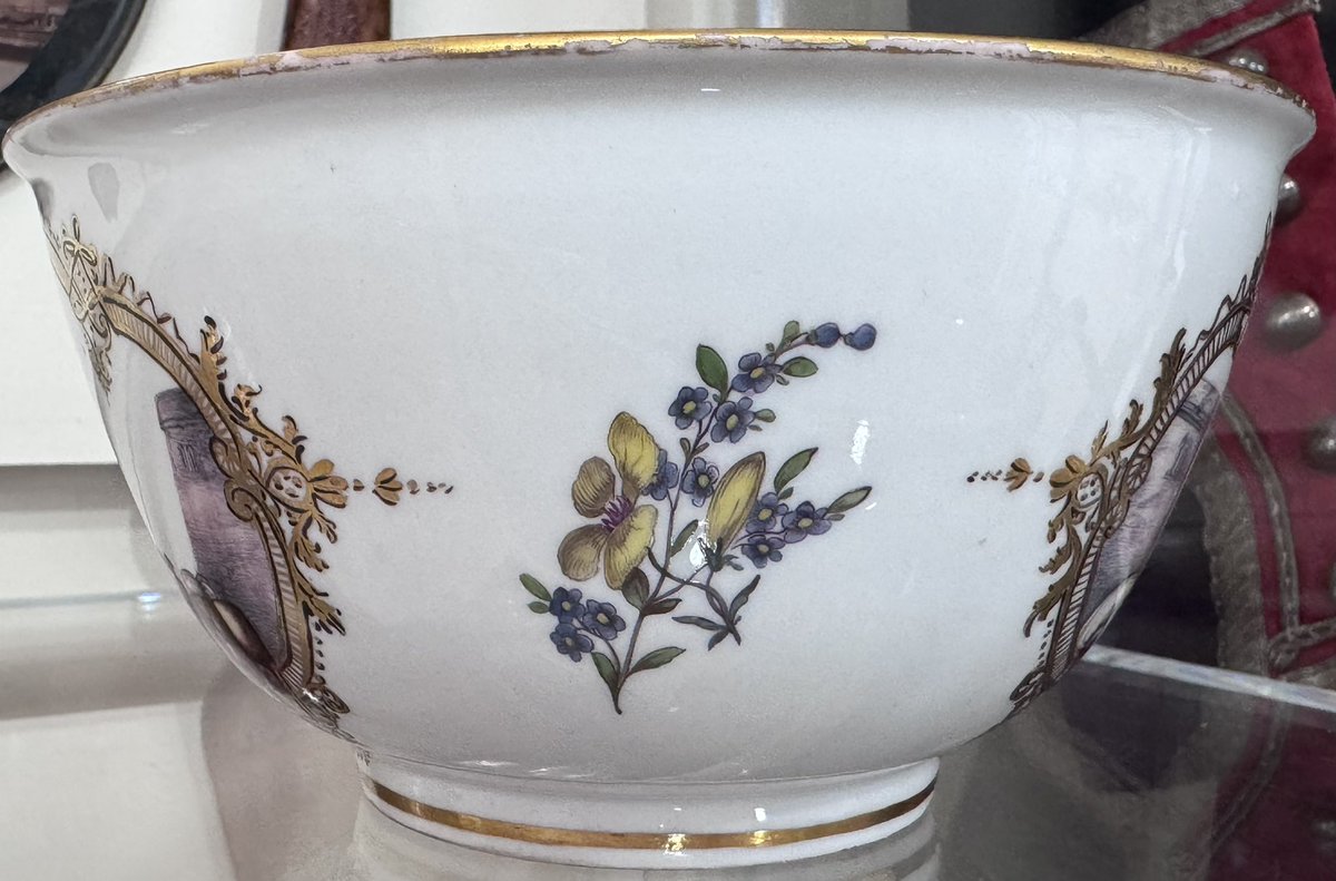 An eighteenth century #Meissen slop or waste bowl, used to empty any liquids from tea drinking. It is decorated with two gilded cartouches containing finely painted harbour and landscape scenes. In the centre of the bowl is another harbour scene contained within two iron red