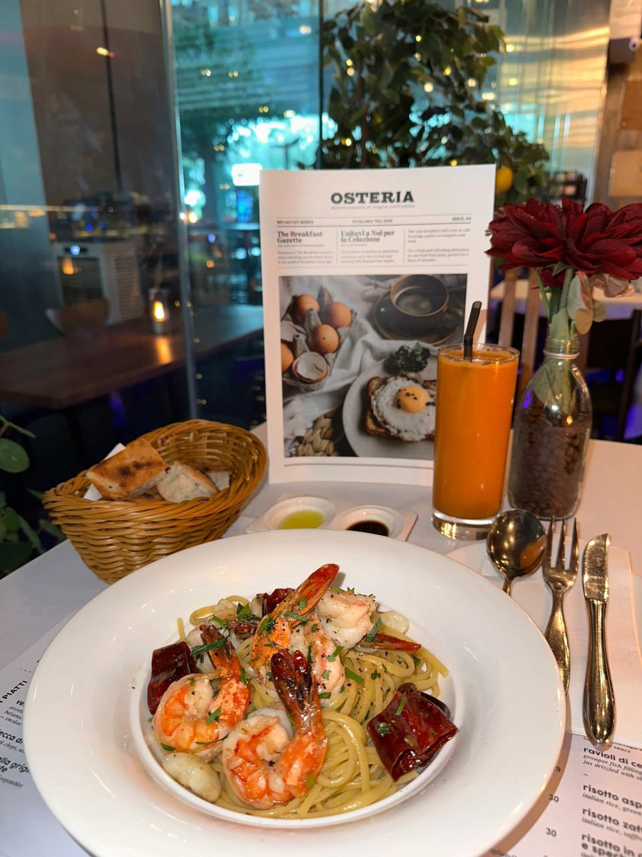 Savoring the perfect bite  garlic prawn pasta, fresh bread, and a splash of sunshine in a glass 🍤🍝🥖🍹 #FoodieVibes #PastaLover #OsteriaMoments"