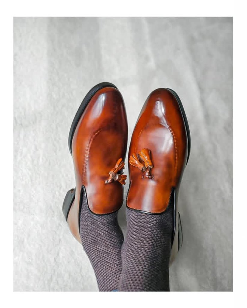 The "Magnifico Tassel" - Our wholecut tassel slip-on in hand-burnished cognac calf, defined by a reverse-stitched split toe apron, sewn entirely by hand.