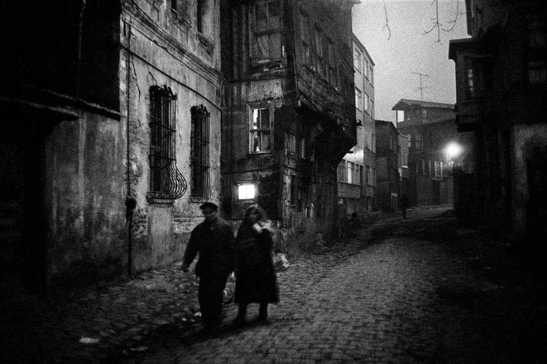 istanblsinema's tweet image. Sokak lambalarının soluk ışığı hiçbir şeyi aydınlatmadığı ve İstanbul’u benim için İstanbul yapan “akşamüstü siyah beyaz” duygusunu çok iyi yansıttığı için, Ara Güler’in bu fotoğrafı bazen aklıma gelir. Benim çocukluk yıllarımdan kalan parke taşları, Arnavut kaldırımları,…
