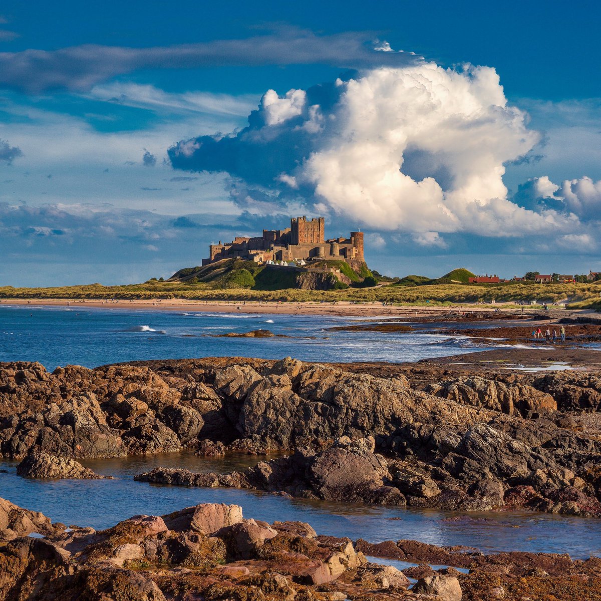 A fore-background layered approach to showcasing a something castle on a somewhere beach