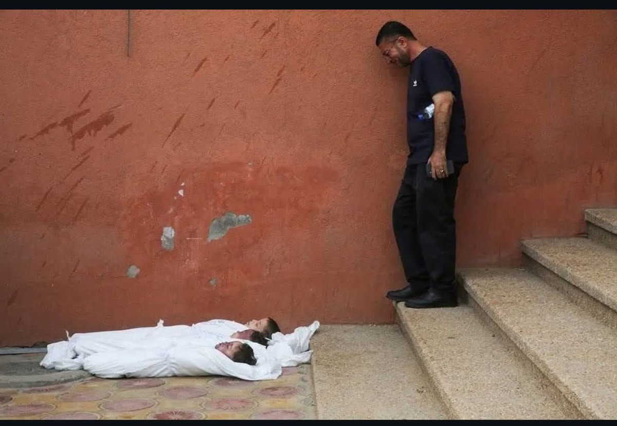 TareqAzzom's tweet image. There is overwhelming deep ache and a bitter sense of betrayal in this image. Three small bodies, still and cold, lie before their father , victims of a brutality that knows no mercy. There are no cries left to echo, no words that can carry the weight of this grief.