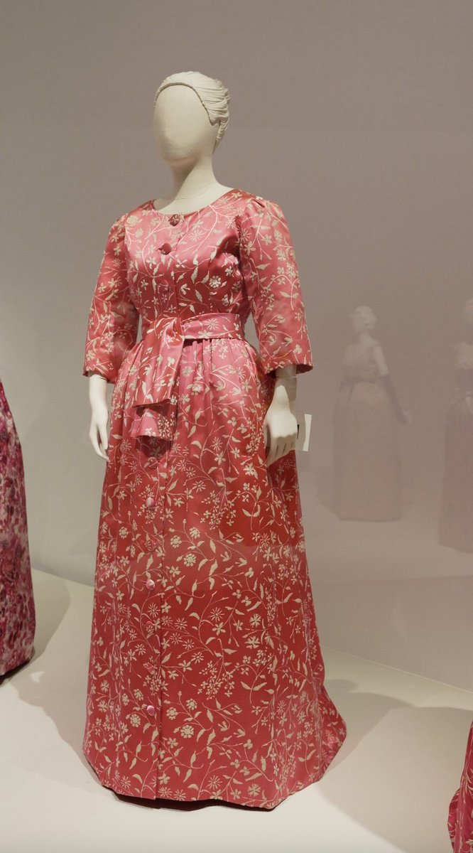 museobalenciaga's tweet image. Este deshabillé combina elegancia y comodidad en cada detalle. Confeccionado en un vibrante tejido bicolor fucsia y blanco, su silueta fluida y mangas tipo hoja aportan ligereza y movimiento, mientras que el escote amplio y el cinturón integrado enmarcan delicadamente la figura.
