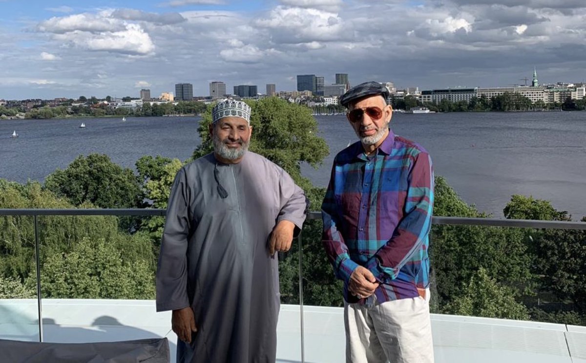 AlsiyabiHamood's tweet photo. مات أبو خالد ! ولكنه لن يرحل 
——————————
 حمود بن سالم السيابي 
——————————
أعرف أن هذا المسجَّى أمام المصلين هو أنت. 
وأنك على غير عادتك في الدخول لبيوت الله ، لم تتقدم نحو المحراب لتقف إماما.  
ولا توسَّطْتَ الواقفين لتكون سترة. 
وأعرف إن نصف الصلاة عليك بكاء. 
ونصفها حيرة ودهشة وأسئلة وعودة موجعة للبكاء. 
 وأعرف أنك مت ، ولكنَّ منْ له في كل ظل وشيجة مع الشجر لن يرحل ، بل سيتكاثر الشجر بالسُّقْيا وسيتَّسع بالضرورة الظل الأخضر. 
ولقد سبقَ وفُجِعَتْ عمان بموت سيدنا الرضي والدك وكان الجميع في المح��ر النخلي فهو علَّامة عصره ، و"موت العالمِ ثلمة في الإسلام لا تُسَدْ". 
وفُجِعْنا بموتك يا أبا خالد وضاقتْ نخل من جديد بما رَحُبَتْ وامتلأتْ السِّكَك ببشر لا نعرفهم ولكنهم عرفوا ��آثرك. 
وكانت المقبرة محشرا نخليا آخر ، لا لأنك نجل العلامة ، بل لأن للأحباب تقديراتهم الوازنة فتساوتْ نظرتهم في أعلميَّة ومكانة والدك ، وفي استحقاقات حزْمة المآثر عندك. 
لذلك جاءوك من كل حدب وصوب في استفتاء نبيل عليك. 
وقد جاهدتُ في تثليج مشاعري بين صلاتي الجمعة والعصر لأتمكن من رؤيتِكَ في أعين الناس ، ولأقرأك فيهم وهم يبكونك كما لم يبكوا أقرب الناس إليهم فخذلتني قدراتي في تثليج المشاعر فبكيتك. 
بكيتُ طفولة جمعتنا رغم أنني الأسَنّ ولكنك دوما الأكبر. 
وبكيتكَ تحسَّرا لتضييع العمر فلم أقدر على مجاراة رجل حفظ القرآن وتعلمه وعلَّمَه. 
وبكيتُ غُررَ الوضوء وحمام�� المسجد ، والوجه الساجد. 
وبكيتُ سفرا جمعنا في "بمبي" صحبة والديْنا وكنتَ نعم الابن البار بأبيك ونعم الصاحب في الس��ر. 
ولربما لو تحدثتْ بوابة الهند وشوارع "كلابا" لقالتْ فيك ما لم يقُله طاغور في ديوان "قربان الأغاني". 
وتوافقنا دون ترتيب مسبق سوى الشوق لمكة المكرمة الذي حجز تذاكره وفنادقه فالتقينا هناك لنترع من ماء زمزم ونتضلَّع ، لعل شربة منها تتبعها شربة من الحوض الأصفى. 
وجمعنا ظلُّكَ الأخضر في سكنكَ ب"بون" فمشينا ذات جمعة زهراء واقتربنا من منزل لآخر سفير عماني في "بون" قبل أن تعيد الوحدة الألمانية الاعتبار لبرلين ، وكيف أن صاحب البيت الألماني ظل محتفظا بلافتة السفير العماني على منزله ، فكنت تُكْبِر هذه الالتفاتة النبيلة في صاحب البيت واعتبرت مسلكه يمثلك. 
وضمَّتنا ضفاف بحيرة "أليستر" في هامبورج وأنت تنضم فيَّ قصيدة لا أستحقها فلم أنشرها واكتفينا بالانصات لنافورة هامبورج ، وما أكثر قصائدك في الآخرين وما أجمل روحك الشاعرة. 
والتقينا على ضفاف بحيرة "رينبك" وكانت قصيدة أخرى تنتظر يراعك ليرصعها بأجمل ما قاله فيها الألمان. 
وافترشنا ظل شجرة في "مولن" بمنطقة "شيليزفيج هولشتاين" الألمانية ومعنا بعض الرطب الذي حملتَه زاداً من عمان.
ولعل النَّوى الذي لفظناه هناك قد استسقى البحيرات فكبر النخل بجوار شجر الزان والسرو والصنوبر فللارض من أيادي الخيِّرين نصيبها. 
وجمعتْنا عاصمة "سيام" ونحن في مستشفى "بمبرونجراد" نتحلق حول فراش الرضية والدتك في ليلتها الأخيرة قبل اللحاق برفيق عمرها سيدها السعيد فكنتَ تنزف وجعاً لأن أمنياتك أن تعود للوطن ووالدتك مع�� فقد اشترت "الصوغات" فلم تشأ الأقدار. 
وكما كنتَ جميلا في الحياة ، فكنت الأجمل وأنت تضع الخاتمة لنصِّك المرصَّع بالأوسمة. 
ساعتها خرجْتَ كعادتك في كل جمعة بدشداشة بيضاء ذات "فريخة" مغموسة في خياراتك من العطر ، ولوَّحتَ بكفك لدخان "المجمر" الذي يفرقع بذوبان حطب العود ، وتأبَّطْتَ بشتك البني بلون النهار وخطبة الجمعة مطوية في يديك وودعت. 
وفي المسافة القصيرة بين عتبة البيت وباب جامع السيد ماجد بن تيمور كنت تهلل وتكبر وتصلي على سيد البشر. 
دخلتَ الجامع واعتليتَ المنبر وسلمتَ وخطبتَ في المصلين عن الصلاة عماد الدين ، ثم جلست بين الخطبتين وأتممتَ خطبتك بدعوة المؤمنين بالصلاة على خير الخلق أجمعين ، فكانت آخر جملة لآخر خطبة لآخر التفاتة للوجوه أمامك وهم يرطِّبون الشفاه بالصلاة. 
لقد انتهى التكليف ، وشيخنا محمد بن سعيد بن خلف الخروصي على موعد بإذن الله بمكان غير المكان ، وبجوار غير الجوار. 
لذلك سأظل أكرر يا أبا خالد أنَّكَ مت.
ولكنكَ لم ترحل. 
 ولن ترحل. 
———————-
مسقط في الجمعة الزهراء ١٥ محرم ١٤٤٧هـ الموافق ١١ يوليو ٢٠٢٥م.
