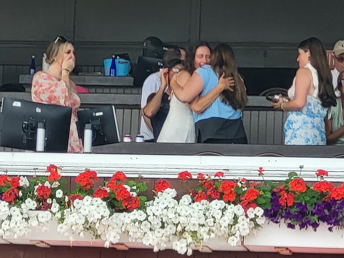 After the 2YO colt Dr. Agne wins the 6th, Dr. Robert Agne's widow, Carrie (white dress), gets a hug from trainer Cherie DeVaux
