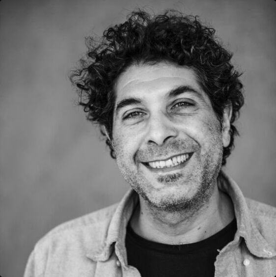 Black-and-white photo of a smiling man with curly hair, captioned as the last thing you see before your identity is sold on the dark web