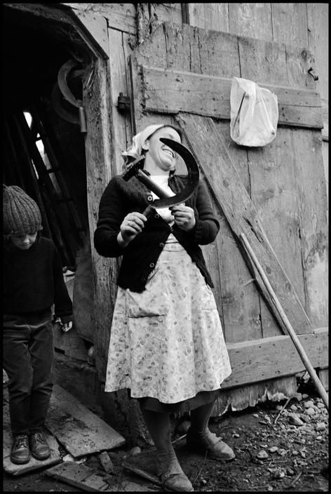 German farm woman showing the Communist symbol with farm tools. West Germany, 1965