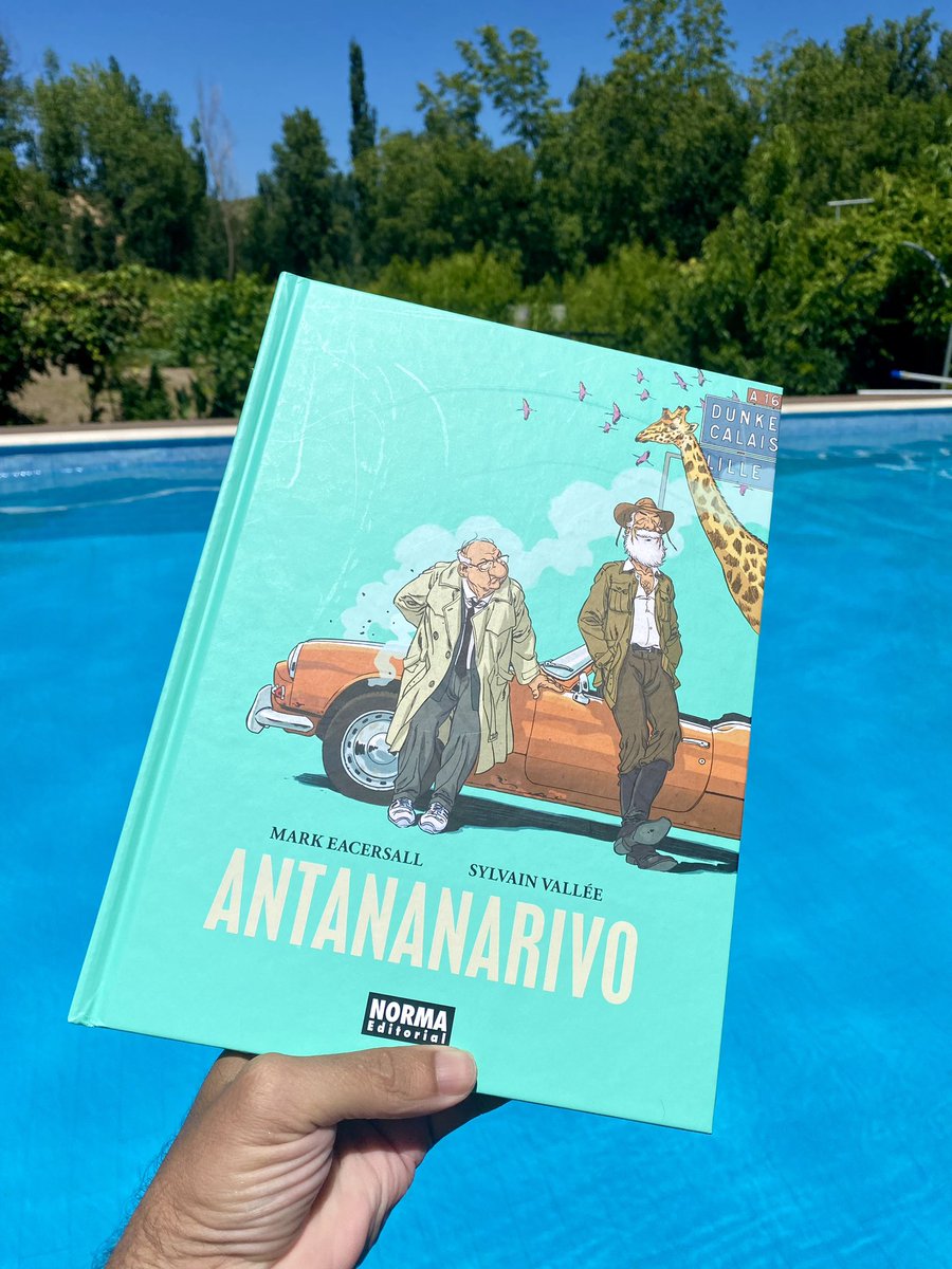 TheBookHunterEs's tweet photo. Antananarivo de @NormaEditorial es, ante todo, una lectura refrescante para sumergirse en verano. Este cómic nos propone una road movie tierna y algo gamberra protagonizada por dos jubilados que, a ratos, recuerdan a una versión contemporánea de Don Quijote y Sancho Panza: uno es el soñador y aventurero que siempre vivió con el viento a favor de la improvisación; el otro, un notario pulcro, ordenado y resignado a haber llevado la vida que se esperaba de él, aunque demasiado gris.

Su amistad, aparentemente improbable, funciona como un espejo de dos maneras de encarar la vida. Por un lado, quien se la bebe a tragos, exprimiendo cada instante en busca de una felicidad casi salvaje; por el otro, quien siguió el guion que se nos impone desde pequeños: formarse, trabajar, casarse… y solo preguntarse por la felicidad como algo secundario y al final del trayecto cuando ya casi no hay tiempo.

La trama los lanza a un viaje que combina humor, nostalgia y una pizca de melancolía, pero siempre con un espíritu vitalista que contagia ganas de lanzarse a la carretera, aunque solo sea desde la tumbona. A medida que se avanza también se pondrá de relieve que no todo lo que reluce es oro, con algún que otro giro amargo, que sin embargo servirá para enfatizar que la vida está llena de obstáculos y que ser feliz empieza por la actitud con la que se encara,por muchas piedras que haya por el camino. 
El dibujo de Vallée, dinámico y lleno de expresividad, redondea esta historia que invita a pensar si aún estamos a tiempo de saltarnos nuestras propias normas. Antananarivo no pretende dar lecciones, pero al lector más maduro y al que la nostalgia y la melancolía de la infancia y juventud pasada (especialmente con los buenos recuerdos veraniegos) le dejará una pregunta flotando en cada viñeta: ¿qué harías si aún pudieras cambiar el final de tu propia historia?
