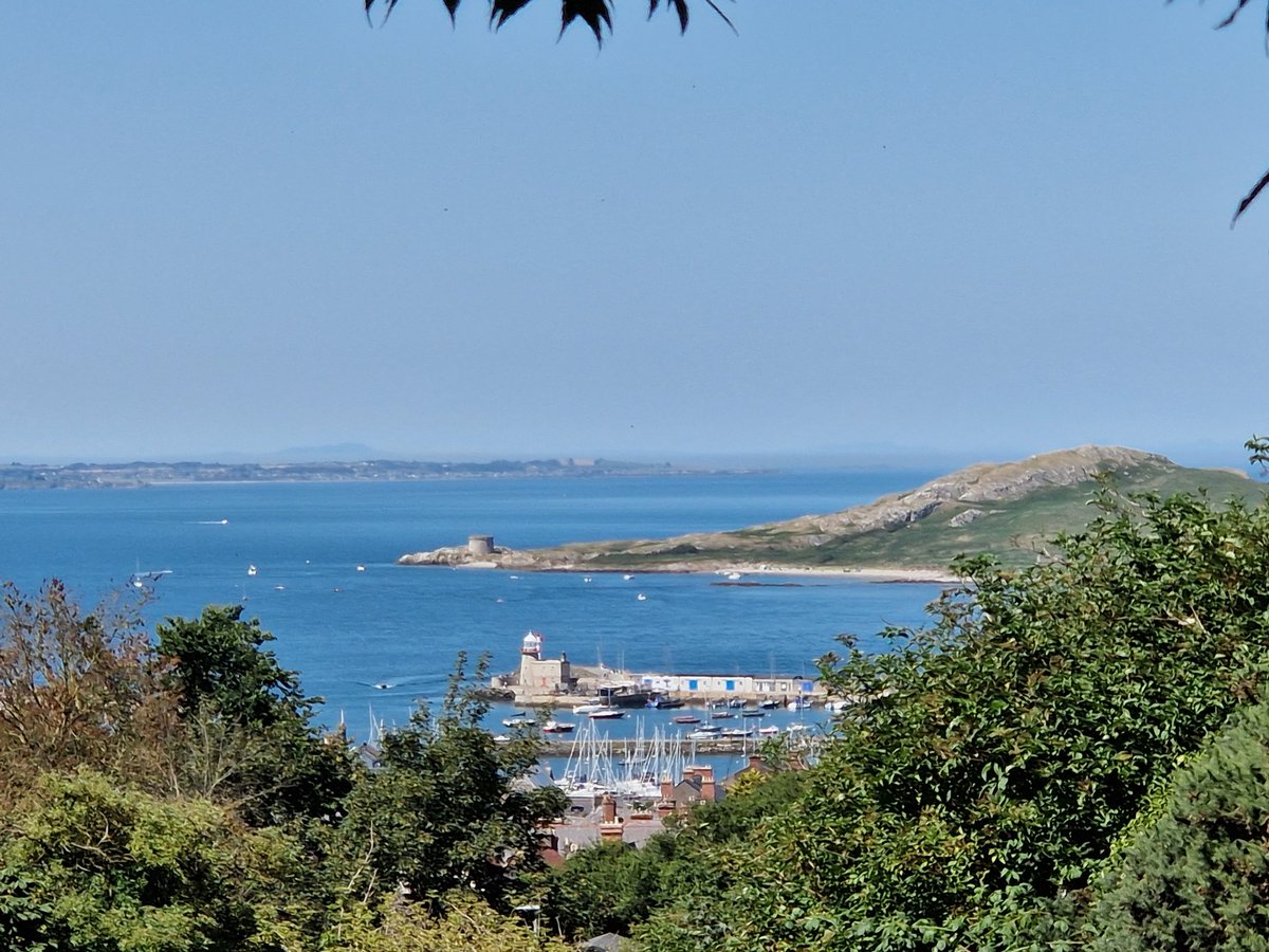 The harbour of Howth with the island of Ireland's Eye beyond in the sunshine.