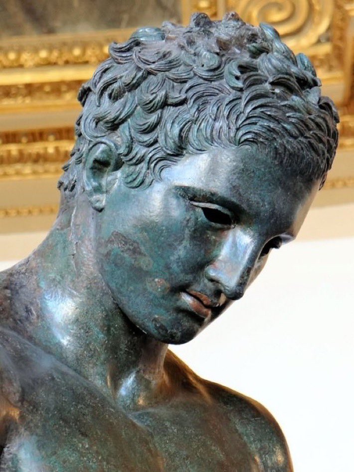 El Apoxiomenos de Croacia, estatua en bronce, siglos II- I a.C. Apoxiomenos es uno de los temas convencionales de la escultura votiva griega, representa a un atleta en el acto de limpiar el sudor y el polvo de su cuerpo con el pequeño instrumento curvo llamado strigilo.