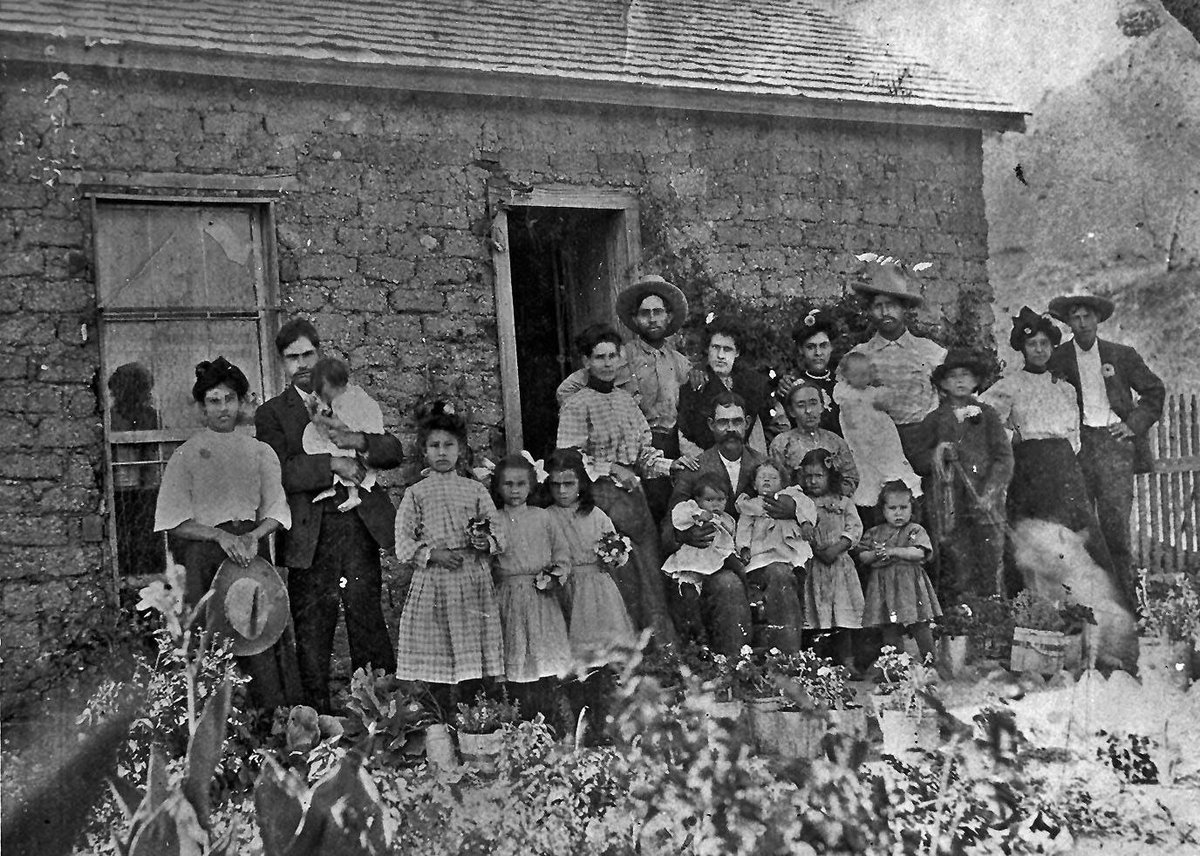 The extended family of Ben and Suzy Gallardo gather outside their adobe family home in Alpine, 1908.