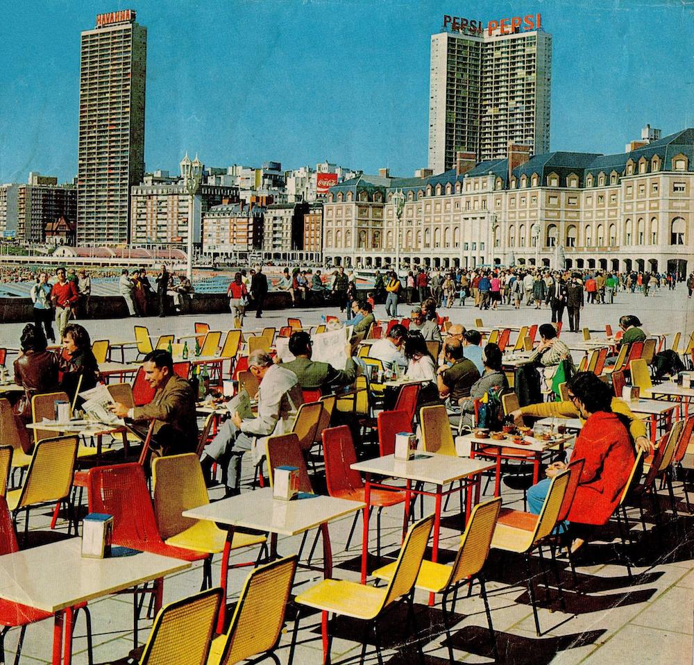 Mar del Plata, principios de los '70. Barcitos de la Rambla en un día de sol, fuera de temporada. Edificios Demetrio Elíades (Havanna) y Palacio Cosmos (Pepsi). Aporte: Pablo Valaco.