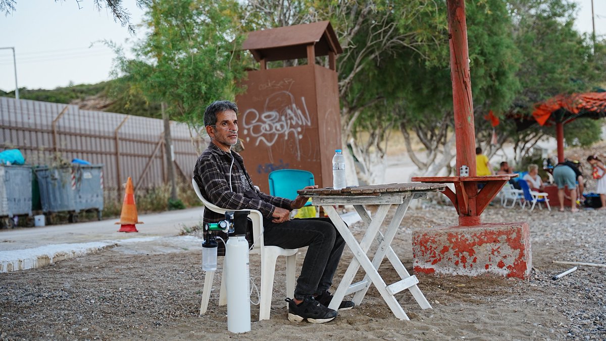 Lavrio kampındaki konteynerin önünde, gün batımının ışığına bürünen bu yastık ve yatak, bir dönem Azadiya Welat ve Özgür Gündem gazetelerinin dağıtımcısı olan Nizamettin Yılmaz’ındı.
Hapiste, tecride karşı 86 gün süren açlık grevi ciğerlerini aldı.
++