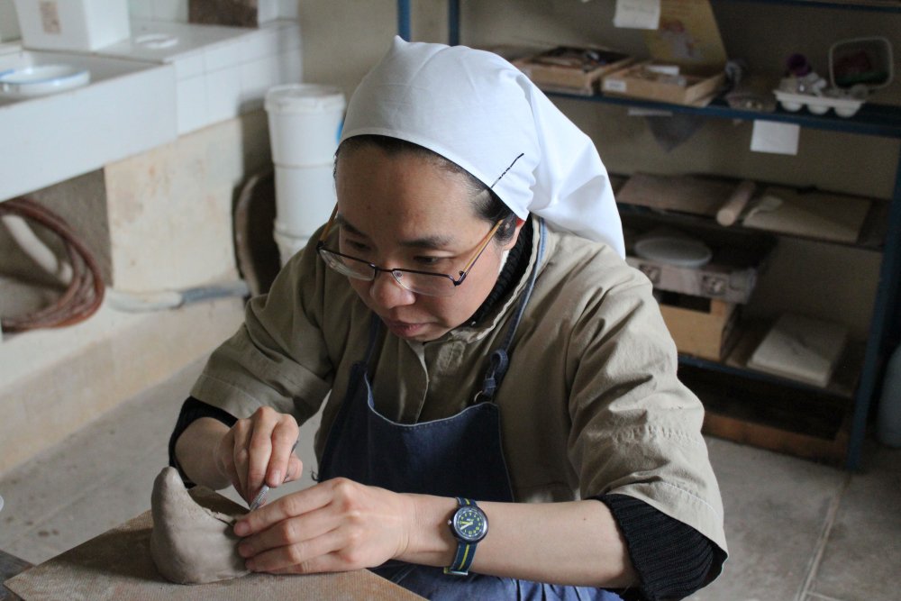 NunsHolding's tweet image. A Cistercian Nun (Order of Cistercians of the Strict Observance O.C.S.O.) at the Abbaye Notre Dame de Bonne Espérance (Abbey of Our Lady of Good Hope) in Echourgnac France holding a sculpting tool as she works with clay. Photo from the Abbey's website at abbaye-echourgnac.org/communaute/la-….