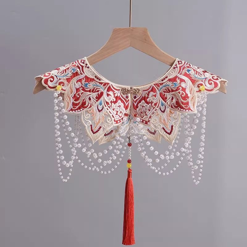 ManusxMachina's tweet image. 唐草と蝶の刺繍付け襟 
manus-machina.com/collections/ne… 
鮮やかな赤地に緻密な金糸や色糸の刺繍がほどこされ、花鳥や唐草模様のような伝統文様が贅沢に広がっています。動きに合わせて軽やかに揺れるパールチェーンは、まるで祝宴の光を受けて煌めくシャンデリアのよう。