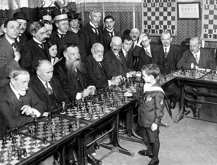 curious_ledger's tweet image. In 1920, 8-year-old chess prodigy Samuel Reshevsky stunned the world by taking on dozens of adult opponents at once—and often beating them. Calm in his sailor suit, he played without notes, pausing only to think. The adults? They could barely keep up.