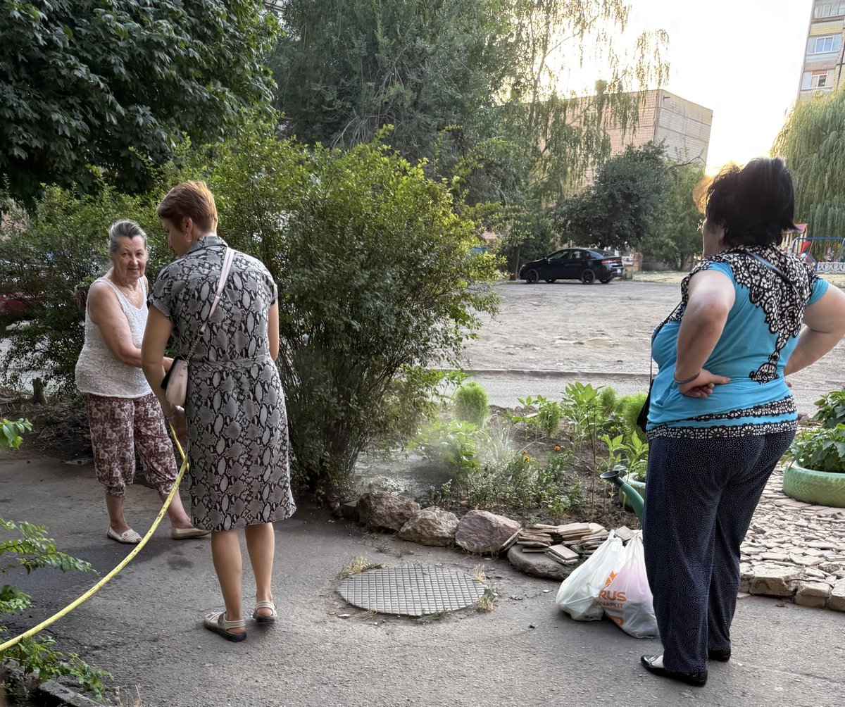 3Bergen's tweet image. Deze dame verfraait de tuin naast haar flat met gebruikte autobanden -die ze steevast mintgroen schildert- en tegels die nu en dan van het gebouw naar beneden kletteren. #KryvyiRih