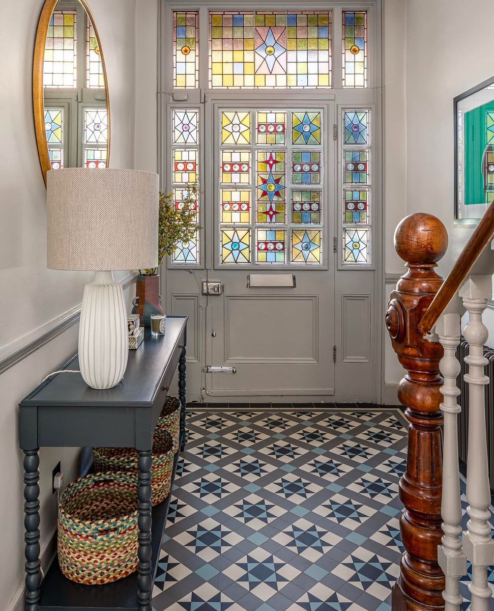This hallway is absolutely beautiful. The stunning stained glass windows must cast a magical glow when the light shines through.