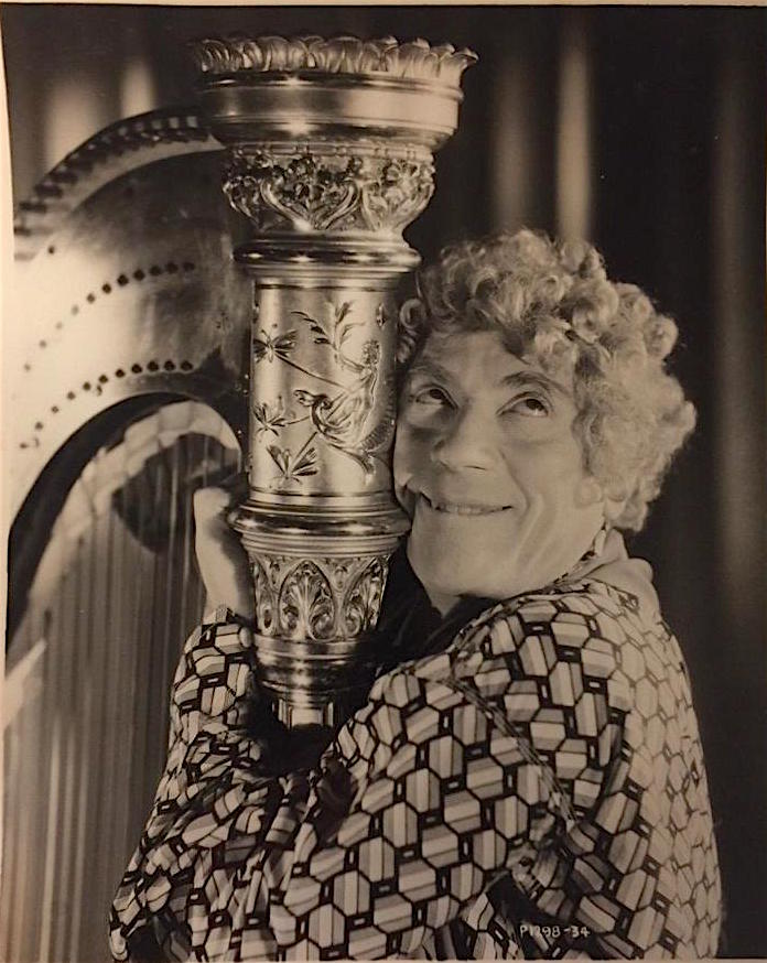 StoliarSteve's tweet image. Uncommon publicity shot of Harpo displaying affection for his eminently appropriate musical instrument during production of &quot;Horse Feathers&quot; (1932). I love the Art Nouveau scene of the young boy in a boat surrounded by dragonflies near the top of the harp.
