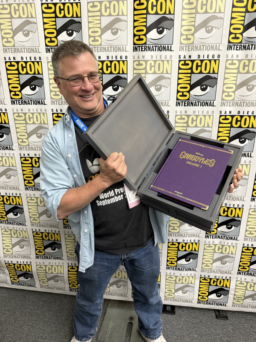 DynamiteComics's tweet image. Greg Weisman poses with the prototype for the Gargoyles Deluxe Edition Treasure Chest at San Diego Comic-Con 2025!