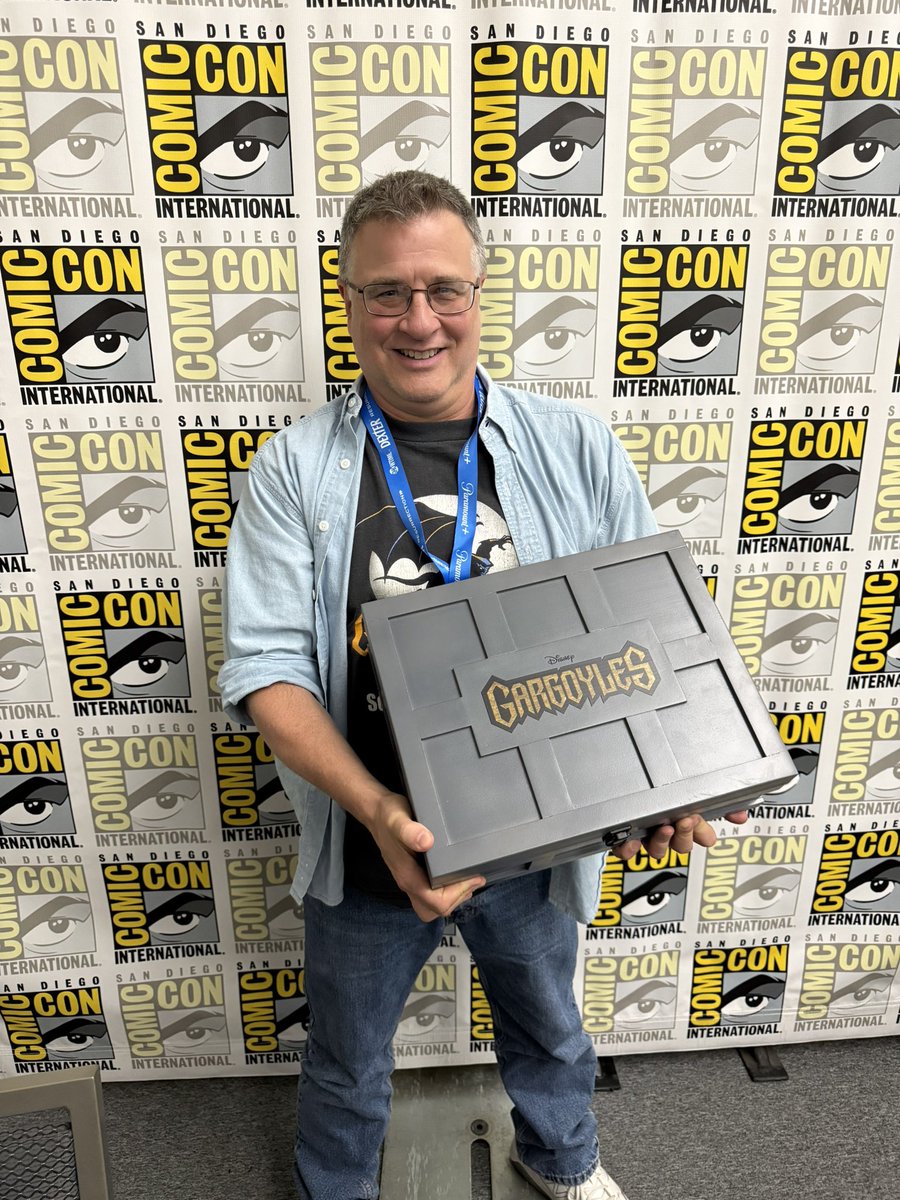 DynamiteComics's tweet image. Greg Weisman poses with the prototype for the Gargoyles Deluxe Edition Treasure Chest at San Diego Comic-Con 2025!