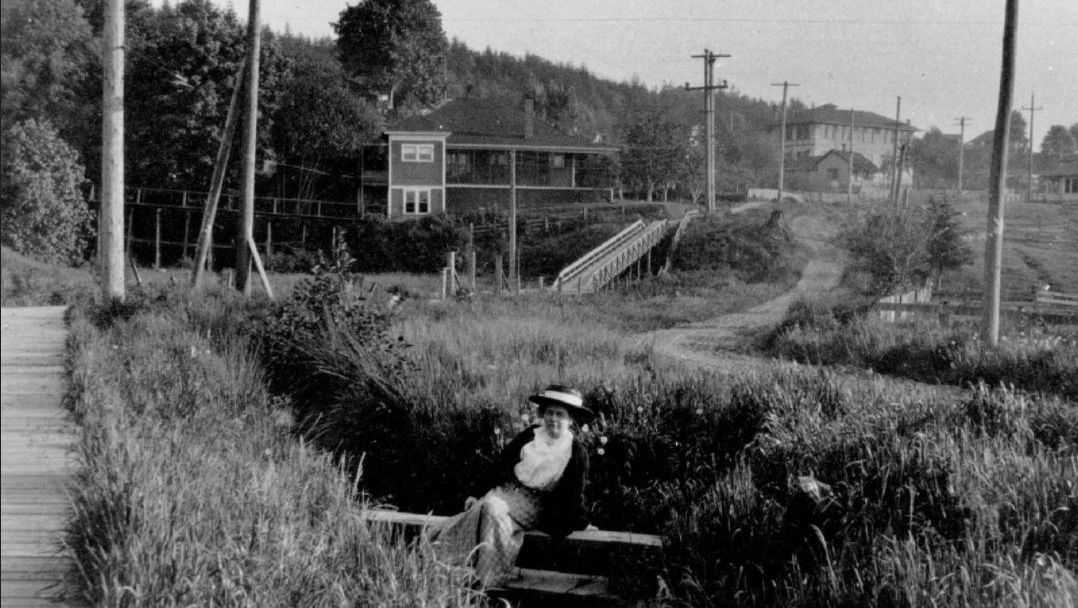 Check out this photo of Vera Sells posing at what later became Earthworks Park in 1920! 
If you look in the background right, you can see the two-story Kent high school!  🏫 #HistoryOfKent