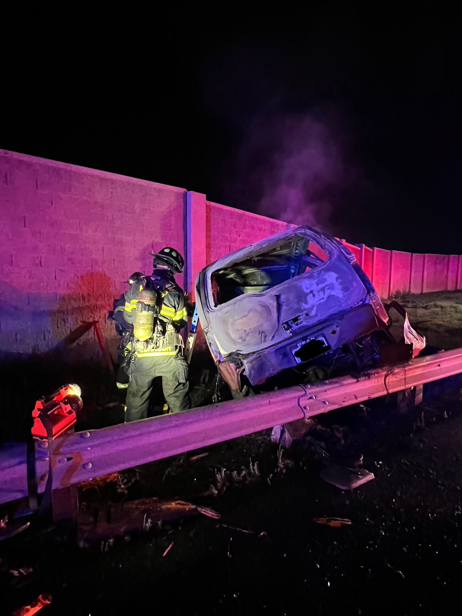 Firefighter near burnt car