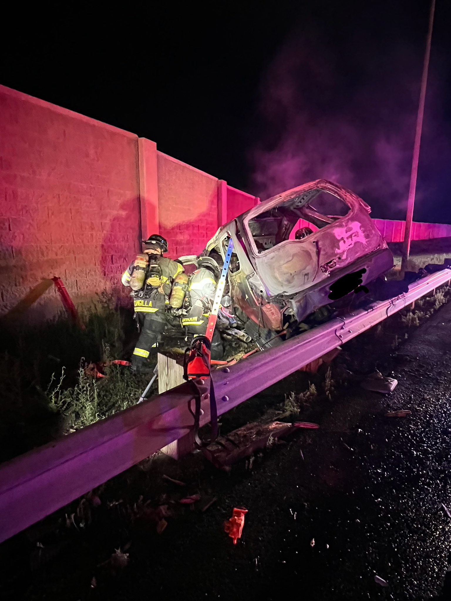 Firefighter near burnt car