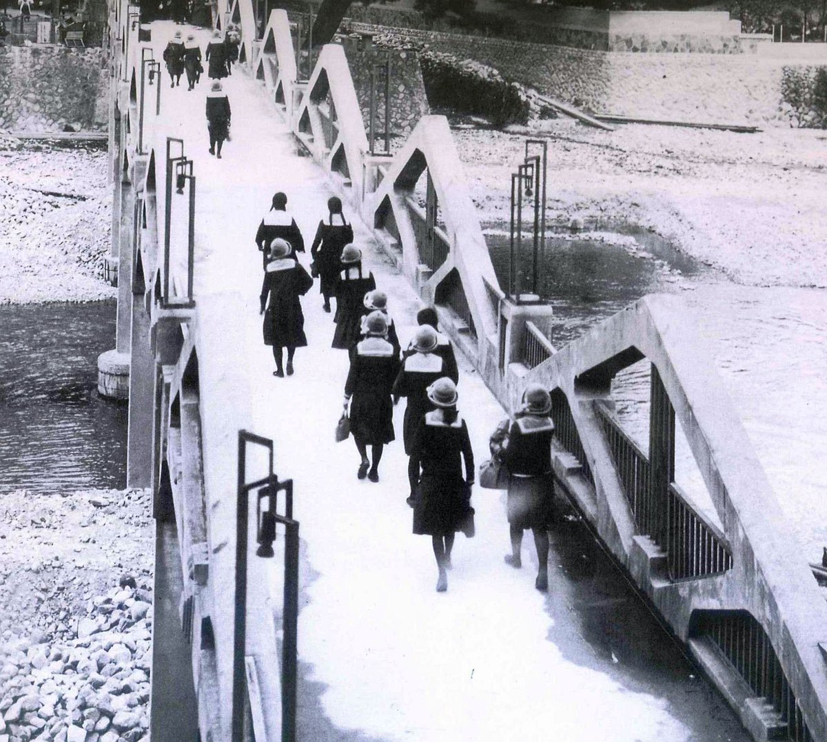 5Te6IA0NzW6JEYj's tweet image. 昭和9年(1934年)、大阪の清水谷高女の生徒たちが遠足で宝塚に来て武庫川を渡っている所です。やはり戦前の女学生と言えば帽子ですね。