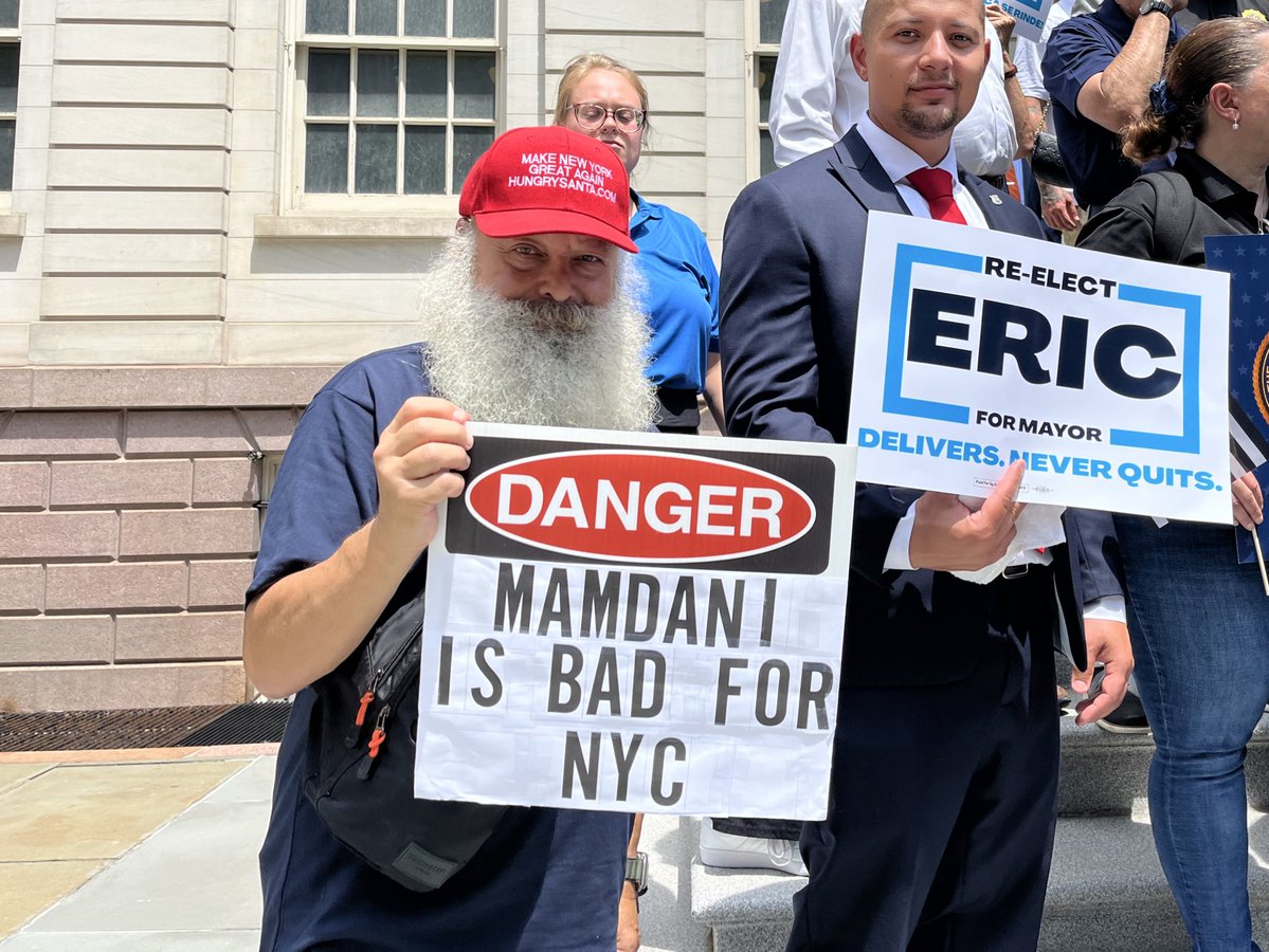 JosieStratman's tweet image. Among the rank-and-file supporters at a endorsement rally for Mayor Adams on the steps of City Hall:
- man with a “Make Adams great again” sign
- man with a “Mamdani is bad for NYC” sign wearing a hat promoting his Santa-for-hire business