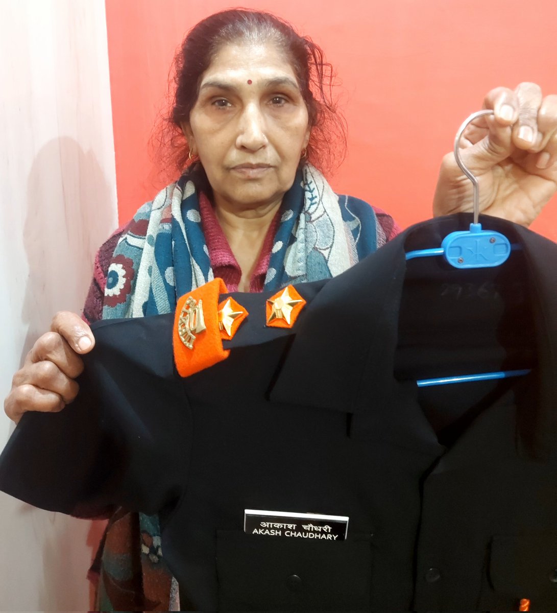 Smt Kamlesh Devi, displaying the  uniform of her only son

LIEUTENANT AKASH CHOUDHARY 
12 SIKH LI - EME #IndianArmy

who was immortalized while serving in Assam #OnThisDay in 2020.

#FreedomisnotFree few pay #CostofWar.