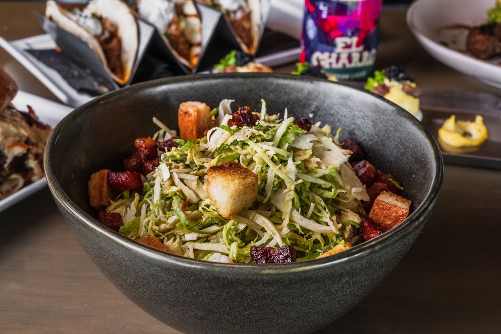 CarsonKitchen's tweet image. Our Brussels Sprouts Caesar are what happens when vegetables try to be the cool kids β a nerd's veggie smothered in parmesan, lardon and topped with bacon fat croutons. This dish is vegetable Stockholm syndrome on a plate, and you'll love every morally questionable bite. π₯π