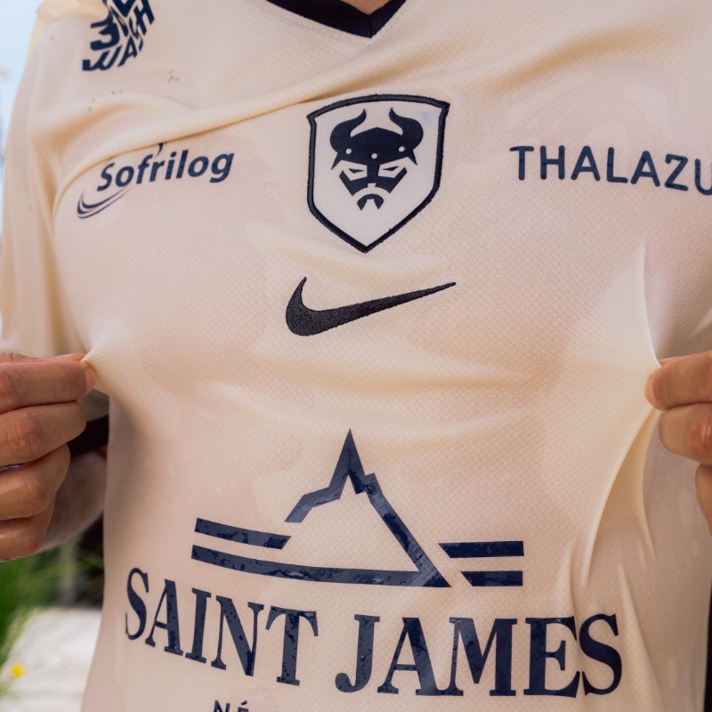 SMCaen's tweet photo. Pour raconter le quotidien, un seul maillot ne suffisait pas. 

Celui-là grimpe la Cavée, passe au marché rue de Bayeux, attend le bus à l’ombre d’un arrêt, file entre les plots à l’entraînement. 

Maillot away 25/26. 𝐈𝐜𝐢 𝐞𝐭 𝐥𝐚̀. 

#SMCaen #TeamSMC