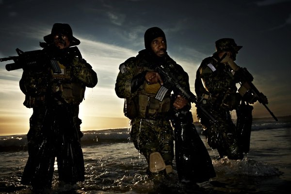 bentley_jubilee's tweet photo. 【『SEALsのガチ勢』『アメリカ海軍特殊部隊の中で最強の部隊だ！』ーーSEAL TEAM6を中心とした仮想敵部隊「レッド・セル」の能力と運用について（戦術の基礎）】

米海軍の「レッド・セル（Red Cell）」は、1980年代に創設された極秘の特殊部隊であり、正式名称を「OP-06D（海軍安全保障調整チーム）」といいます。

その任務は海軍施設の警備体制をテロ攻撃に見立てて検証するためのアグレッサー部隊でした。

1983年10月のベイルート米海兵隊兵舎爆破事件で241名が犠牲になった事例などによって米軍施設へのテロの脅威が懸念されるようになり、当時海軍作戦部副部長だったジェームズ・エース・ライオンズ提督は海軍の備えに慢心がないか問題視しました。

そして1984年初頭、ライオンズ提督は当時Navy SEALの対テロ専門部隊SEALチーム6の初代司令官であったリチャード・マルシンコに対し、新たな模擬敵部隊を編成して基地の脆弱性を実証するよう命じました。

マルシンコは直ちに精鋭隊員のリクルートを行い、自ら初代指揮官に就任します。

レッド・セルの創設メンバーは総勢14名で、内訳はマルシンコと彼が以前率いていたSEALチーム6の出身隊員13名に加えて米海兵隊特殊部隊フォースリーコンから1名が選ばれました。

チームはペンタゴン所���とされ、通常の基地や司令部を持たずに秘密裏に活動しました。

組織上はライオンズ提督直属の扱いであり、他の部隊から独立して行動の自由が与えられていました。

マルシンコの自伝によれば、レッド・セルの非公式な根拠地はバージニア州アレクサンドリア市内の「シューター・マクギー」という酒場であったとも言われています。

なお「レッド・セル」という名称は、もともとアメリカ国防関係者の間での仮想敵チーム『Red Team』を指す用語に由来します。

西側の軍事演習では敵側を赤、味方側を青と呼ぶ伝統があり、それを単独の特殊部隊名として採用したものです。

マルシンコはこの新部隊に非公式に「レッド・セル」の名を与えました。

部隊の創設背景には対テロ対策の必要性と、当時の海軍施設警備に存在した隙を洗い出す狙いがありました。

レッド・セルはその目的のため「模擬テロリスト部隊」として実際の軍事設備や人員を標的にアグレッサー部隊として訓練攻撃を仕掛け、問題点を浮き彫りにするというユニークなアプローチを取ったのです。

【レッド・セルの運用目的と任務の変遷】

創設当初のレッド・セルの主目的は、米海軍基地・艦船に対するテロリストあるいは特殊部隊による攻撃への脆弱性評価でした。

高度に訓練された部隊員がテロリストになりすまし、海軍の施設防衛計画を実地に試すことで防御上の欠陥を明らかにすることが求められました。

具体的には、基地に侵入して要人を拉致したり、艦船・飛行機・重要施設に模擬爆弾を仕掛けたりする想定攻撃を行い、その過程で発見した警備体制の弱点を上層部に報告する役割です。

レッド・セルチームは事前に「ある時期に基地の警備評価を行う」ことを通達しますが、攻撃��詳細である侵入手口や時刻などは完全に秘匿し、現場部隊を想定外の奇襲に曝すことでリアルな反応を引き出しました。

当初、レッド・セルの活動は従来になかった徹底した想定敵視点のものであり、海軍首脳部はその成果に注目しました。

レッド・セルが暴いたセキュリティ上の欠陥に対し、海軍は速やかに対策を講じ、1986年6月にはジョン・レーマン海軍長官の命令で海軍全体の基地警備体制の大規模な再編成が行われています。

この再編ではレッド・セルの指摘を受けた基地に対して警備大隊を増強配備する措置や、従来寄せ集めだった基地警備の専門職化など、長期的な対策の検討も行われました。

こうした動きからも、レッド・セルの活動が海軍の対テロ防御力向上に一定の貢献をしたことが窺えます。

一方で、レッド・セルの任務内容には時期とともに変化や拡大も見られました。

当初公表されていた基地防御テスト任��はある種のカバーストーリーでもあり、水面下では国外における実戦的な対テロ特殊任務への準備も想定されていたと言われます。

特殊部隊員の強みを活かし、必要に応じて外国でのテロリスト無力化作戦としてイスラエルや英国の対テロ攻撃部隊が行うような任務を遂行できる能力部隊として育成する意図もあったとする見解です。

実際にレッド・セルは海外米軍施設での演習も多く経験し、冷戦下の1980年代に世界規模で増大するテロ脅威へ即応するための予行演習の場ともなっていきました。