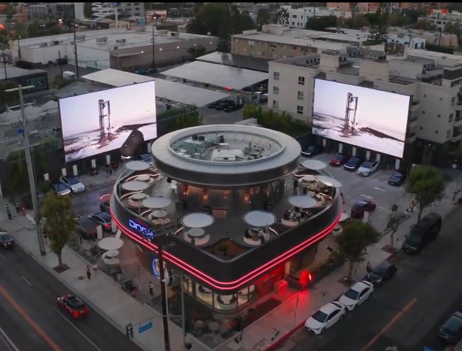 SawyerMerritt's tweet image. Elon confirms that you will be able to order food at @Tesla’s new Hollywood Diner directly from the screen inside your Tesla. The audio of movies/videos playing on both 45-foot LED screens will also sync and play from the speakers inside your vehicle