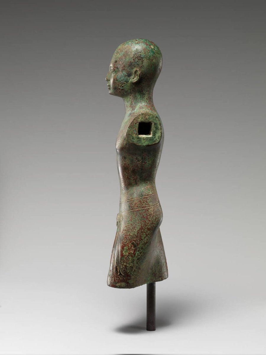 Cette sculpture représente un prêtre koushite vêtu d'un vêtement orné d'une tête de léopard et de glands, symbole à la fois du pouvoir religieux et royal. Ce vêtement fut plus tard adapté pour être porté par un roi.....