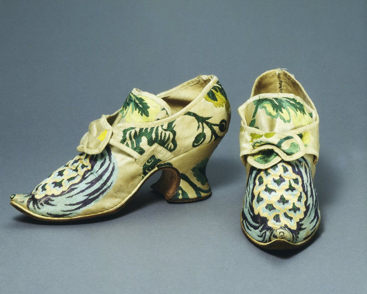V_and_A's tweet image. Silk footwear in the 18th century reflected elegance and status. Women’s shoes featured curved heels, pointed toes, and silk uppers with detailed floral motifs. Intended for indoor use only, they fastened with cut steel buckles. Outdoor wear required practical leather boots.
