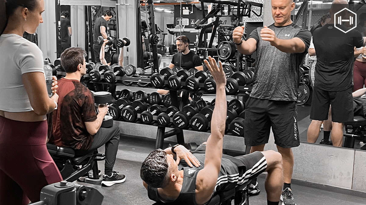 When teaching the dumbbell bench press, it’s not just about pushing weight, it’s about how the client connects with the movement.

Start by cueing them to pinch their shoulder blades back and down to create a stable base. The dumbbells should move in a slight arc, not straight up