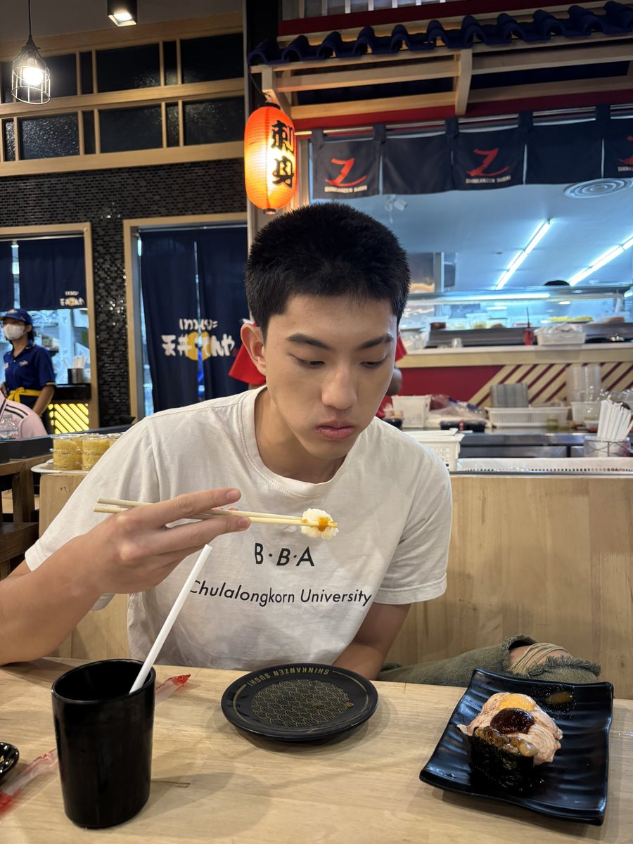 I took a picture of phi 𝗞𝗲𝗻 eating sushi, and his facial expression looked like he was thoroughly enjoying his meal. He seemed to savor every bite of sushi, and he looked very satisfied with the taste and texture of the food.