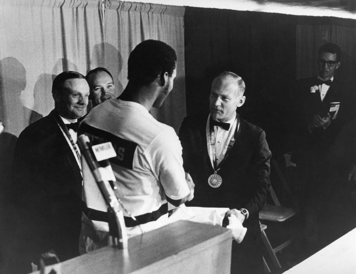 MUOverload's tweet image. Team captain Joe Thomas gives @MarquetteMBB warmups to Apollo 11 astronauts Neil Armstrong, Michael Collins, and Buzz Aldrin on November 8, 1969 at the Père Marquette Discovery Award ceremony #mubb