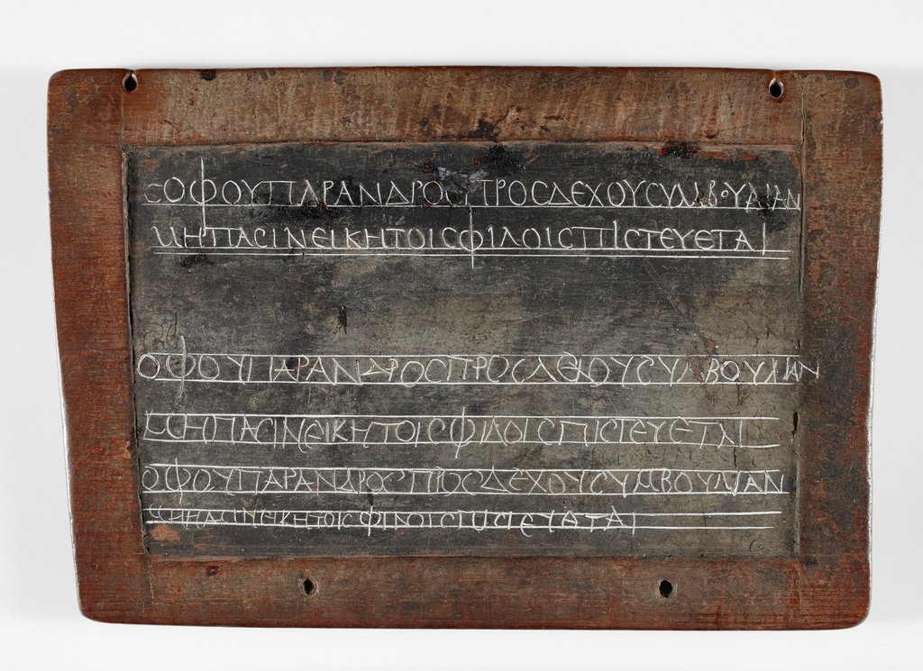 Athanasius_45's tweet image. A well preserved wax tablet from Roman Egypt with a writing exercise in Greek. The first two lines were written by the teacher, the following four are copy attempts by the student.
Σοφοῦ παρ’ ἀνδρὸς προσδέχου συμβουλίαν (Menander)
Μὴ πᾶσιν εἰκῇ τοῖς φίλοις πιστεύεται