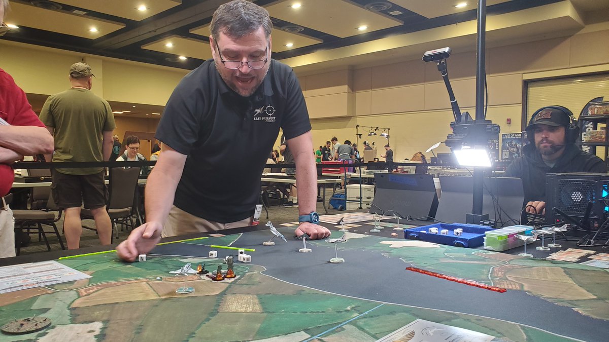 HMGS_Inc's tweet image. Doug Glover & the crew of Lead Pursuit were streaming games of Blood Red Skies-Beyond MiG Alley all weekend at #Historicon2025. Their presence added a great energy to the Exhibit Hall & we are grateful they joined us. Check out their YouTube to understand Doug's expression below!
