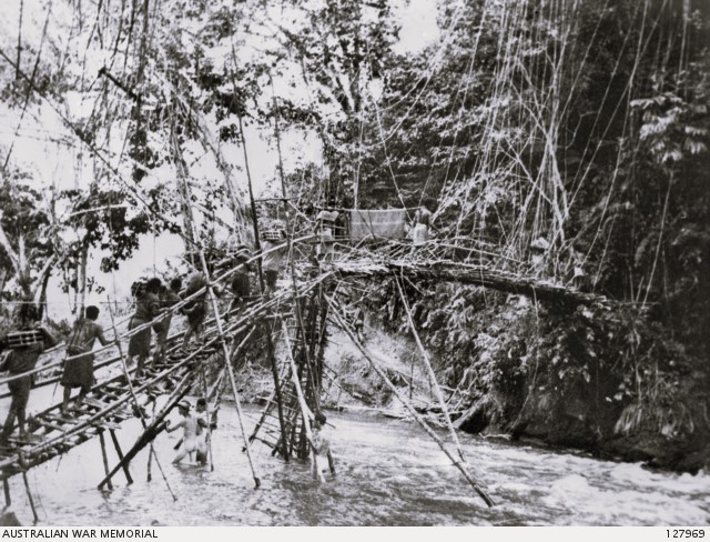 DWB55's tweet image. July 1943
New Guinea:
New Guineans cross a vine bridge over the Francisco River enroute to front line.
They carried mortar shells, stores and wounded soldiers on their shoulders over some of the toughest terrain in the world.
3 naked Australian engineers are at work in the river.