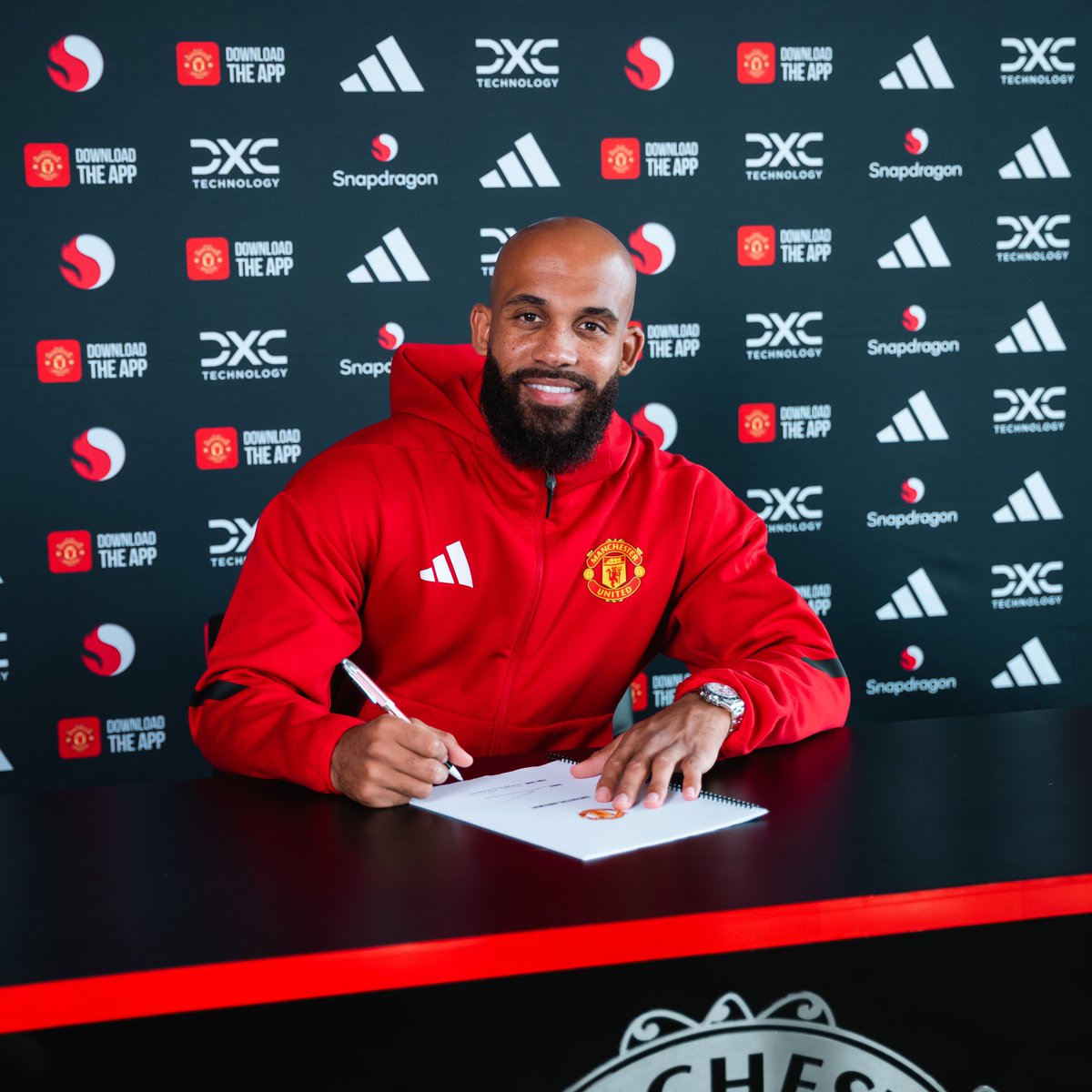 Bryan Mbeumo signs as a Manchester United player.