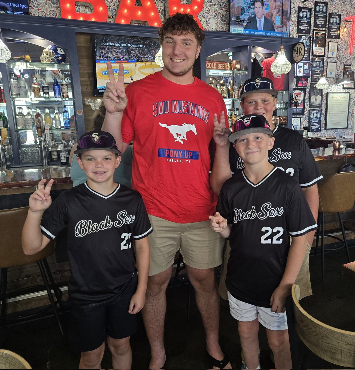Holly_G75's tweet image. Proud parent moment! Having lunch w/ Evan. A youth baseball team is there raising money for their summer league. Fascinated with Evan, taking bets on if he plays football for SMU. Evan takes a pic with them, and then donates $30 of his lawn mowing money to their team🥹❤️