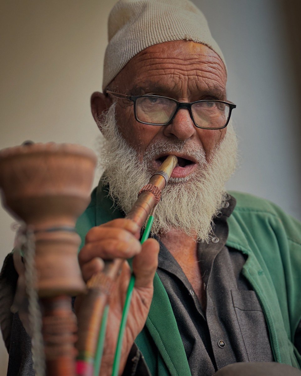 ashishsphotos's tweet image. Somewhere in Hapatnar — a quiet village hidden among the misty pine slopes of Pahalgam — time slows to the rhythm of raindrops. The air is damp, cool, and filled with the earthy scent of wet soil. He draws slowly from his pipe, smoke curling into the rain-soaked breeze, while she…